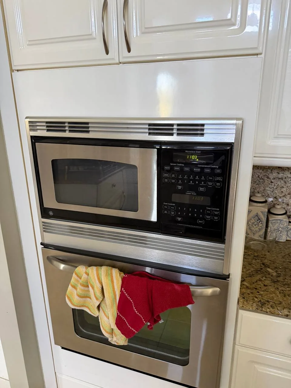 A stainless steel microwave and oven combination unit installed in a kitchen cabinet