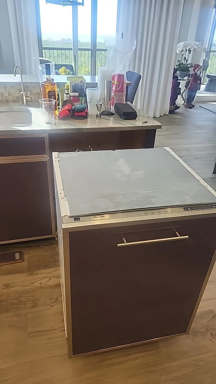 A Viking dishwasher with its top panel removed in a modern kitchen