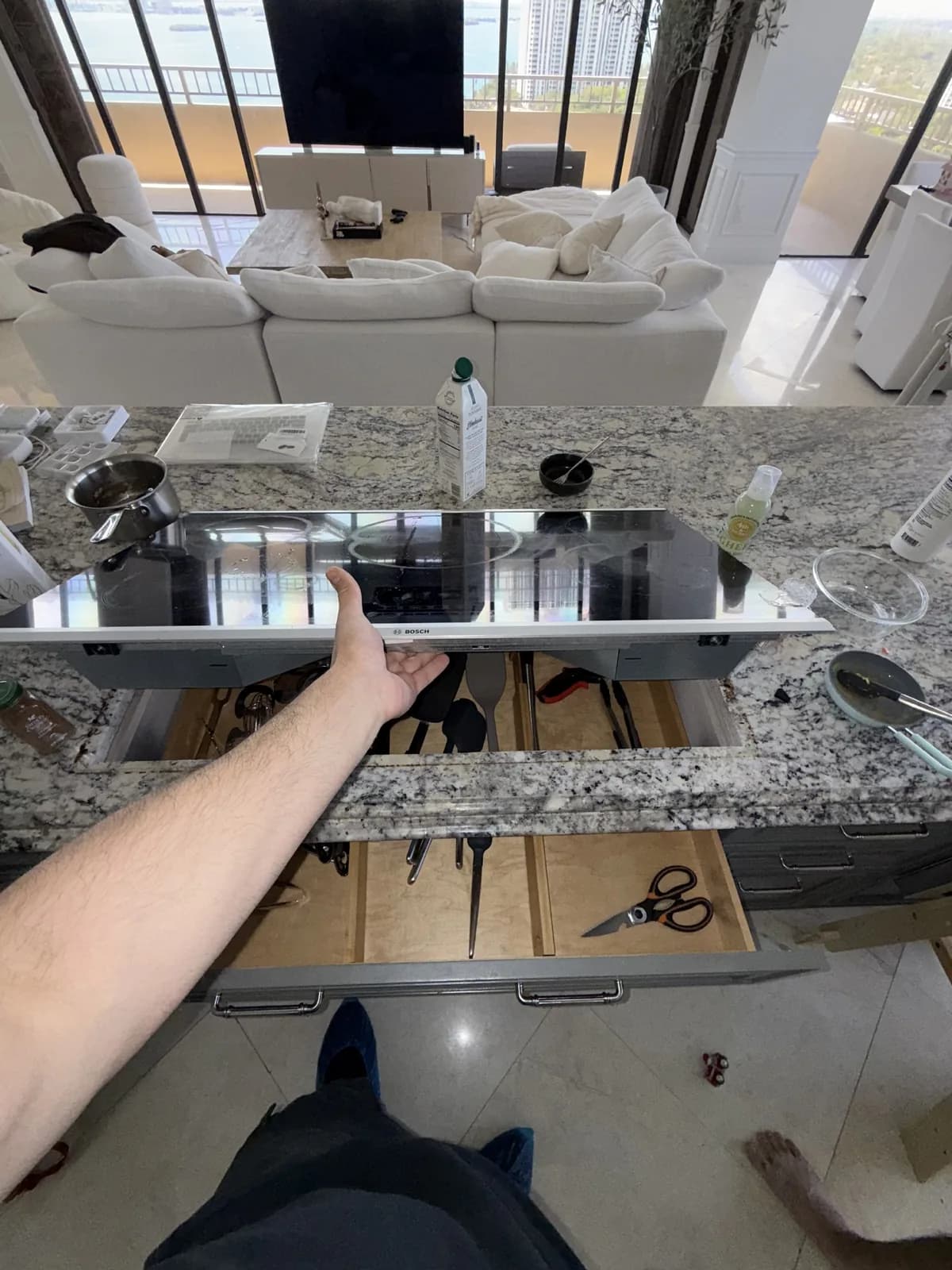 A technician working on a cooktop, which is installed in a kitchen island