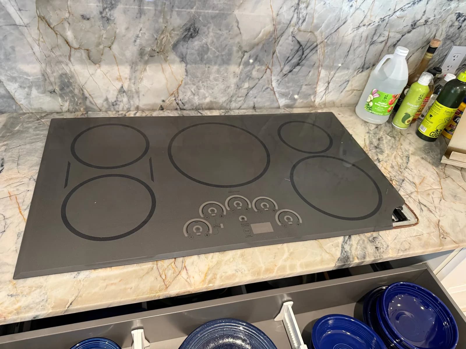 A cooktop with multiple burners and controls is installed in a kitchen counter