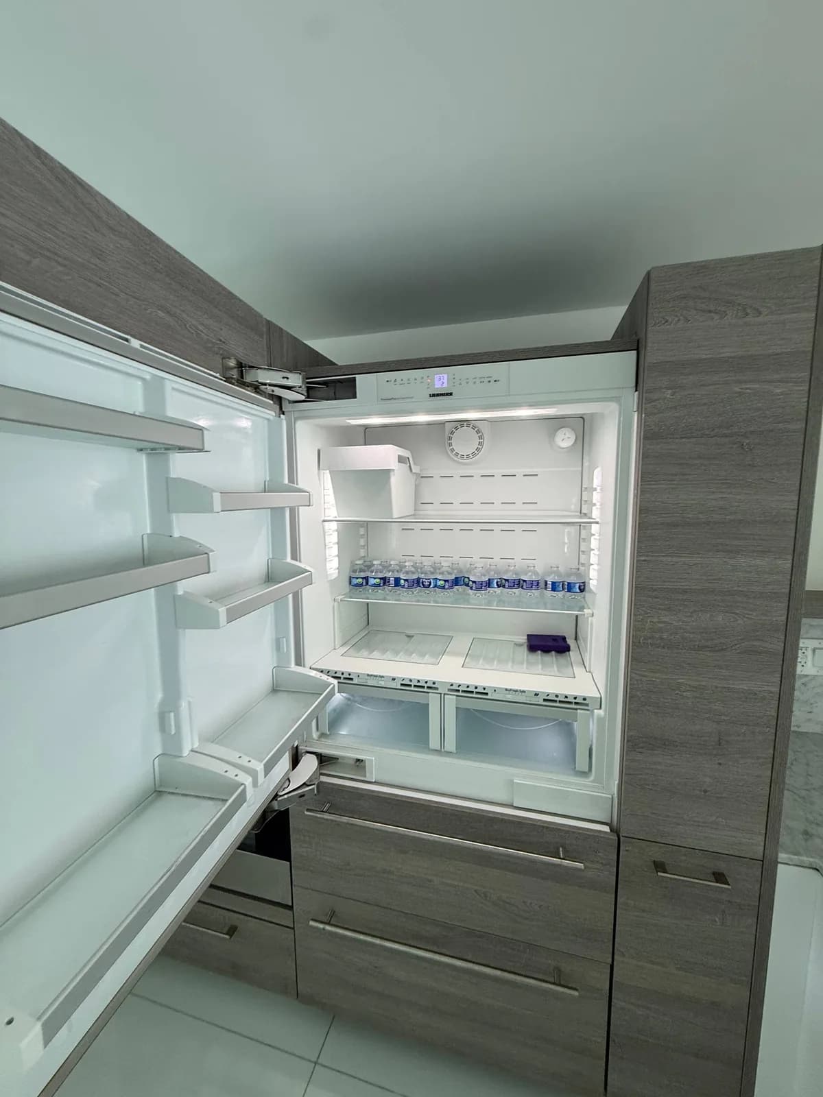 A full shot of an open Liebherr refrigerator with drinks inside