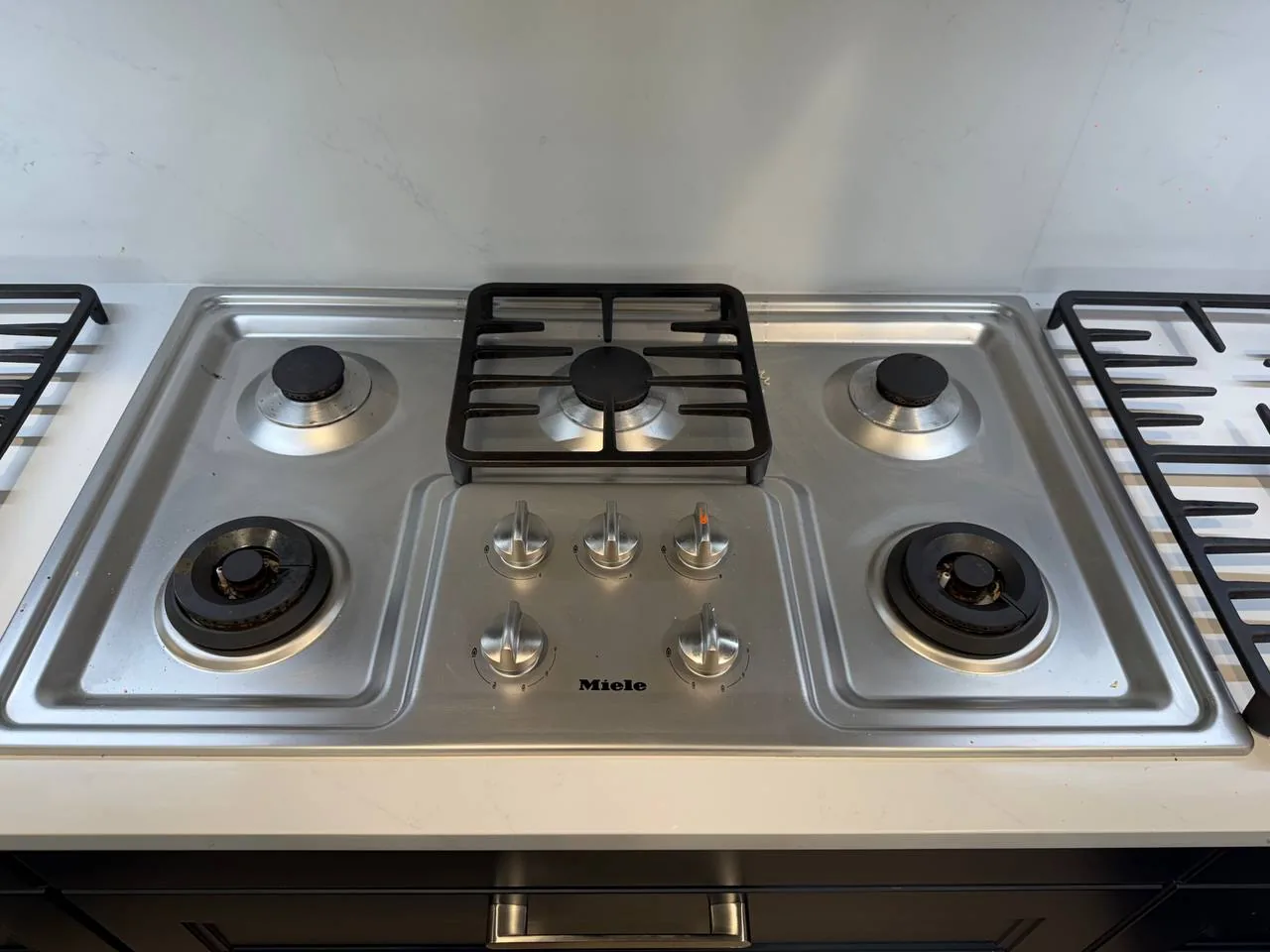 A Miele cooktop with multiple burners and control knobs, ready for repair