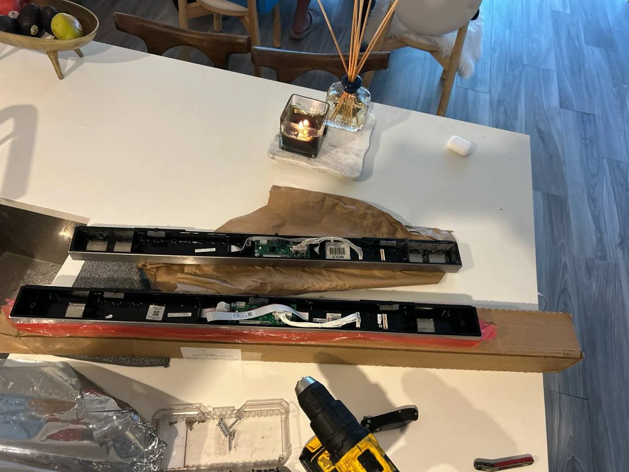 The new electronic control panels for a Wolf oven laid out on a table next to tools